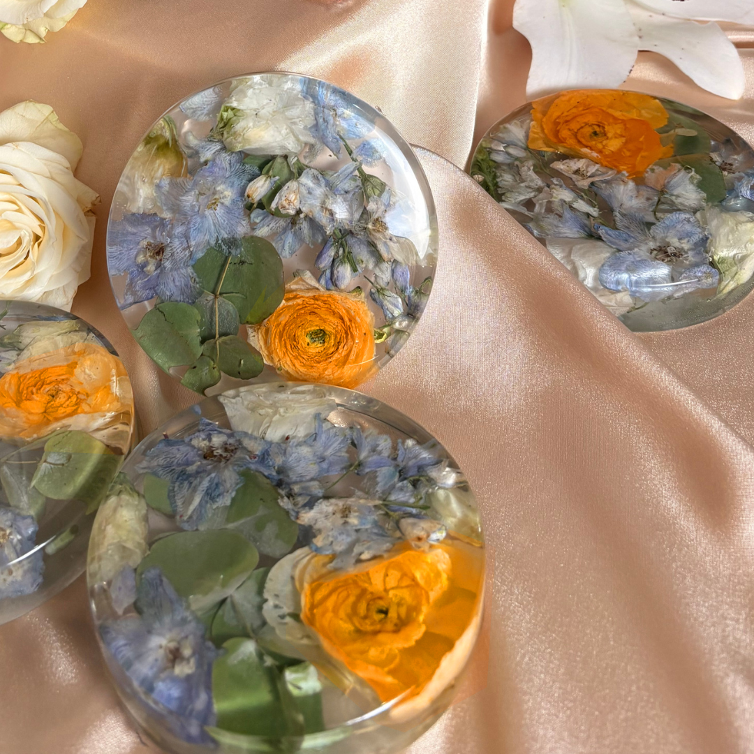 Set of four round resin coasters filled with blue and yellow flowers and eucalyptus leaves. Beautiful resin preservation of your bouquet.